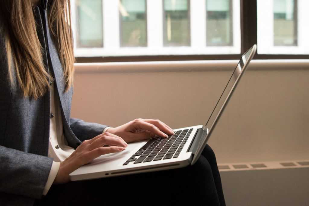 woman using a laptop sitting on her lap