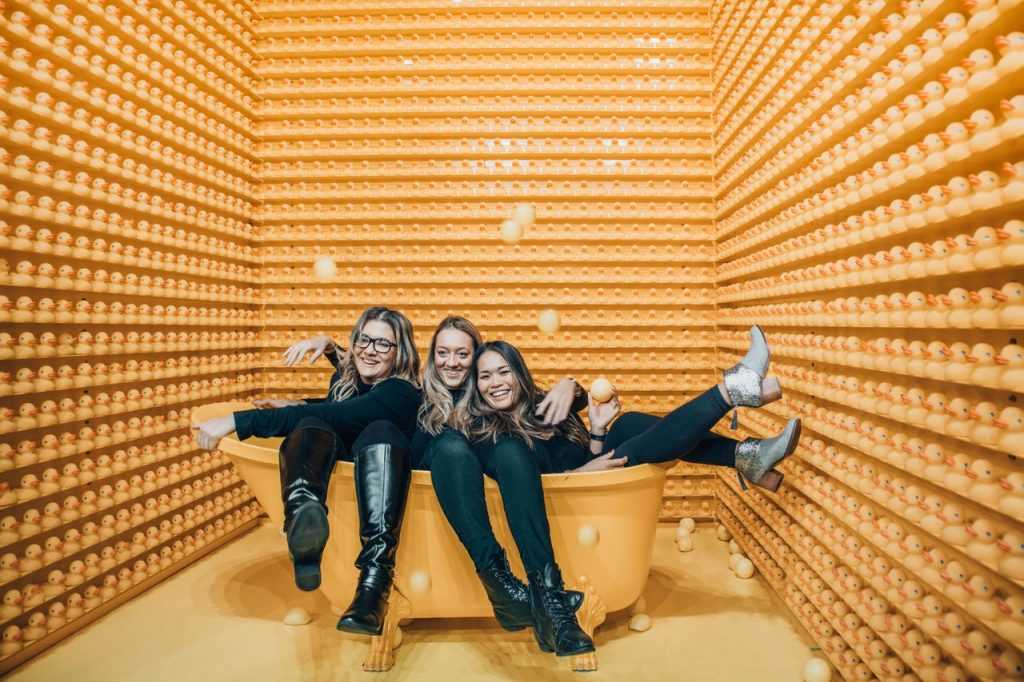 three women sitting in a bathtub