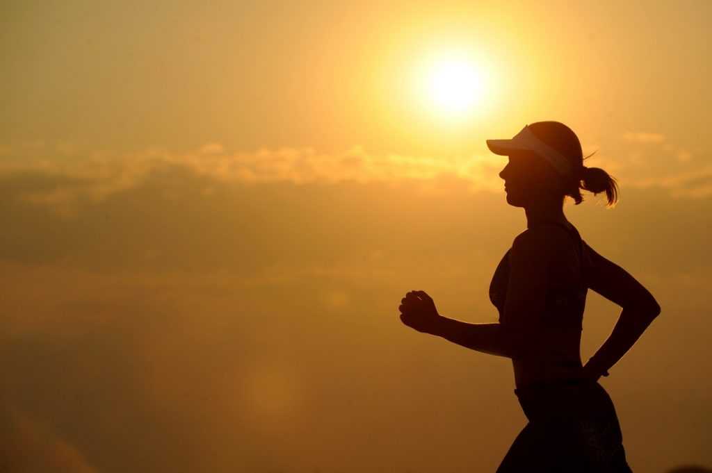 woman running with sunset in the background