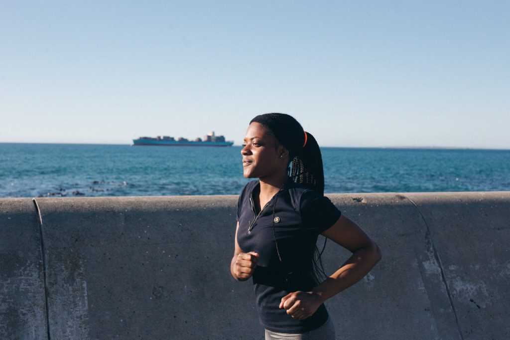 woman running with ocean in the background