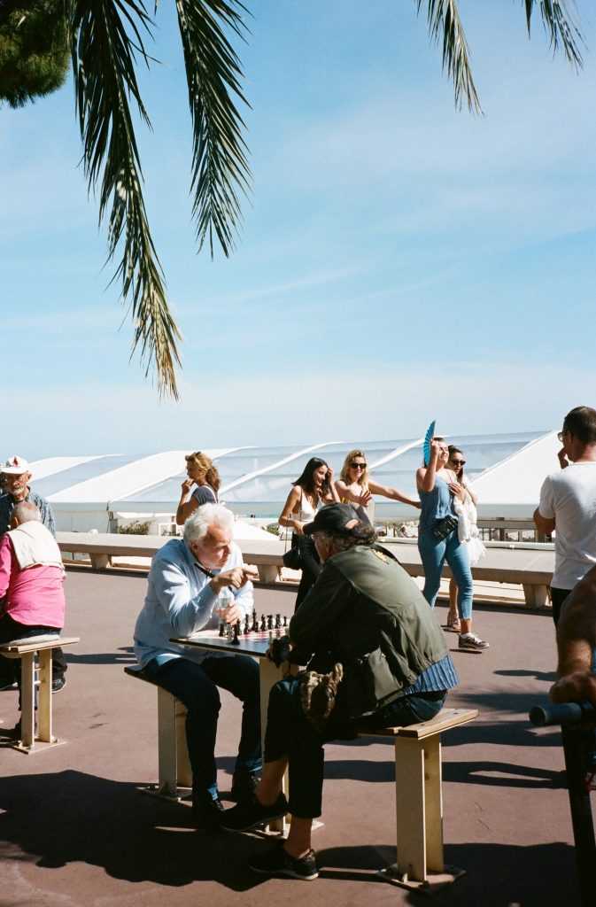 old folks playing chess outside at the park