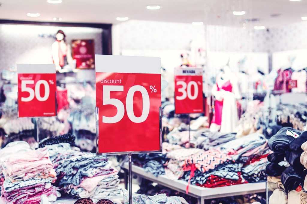 piles of clothes on tables for sale