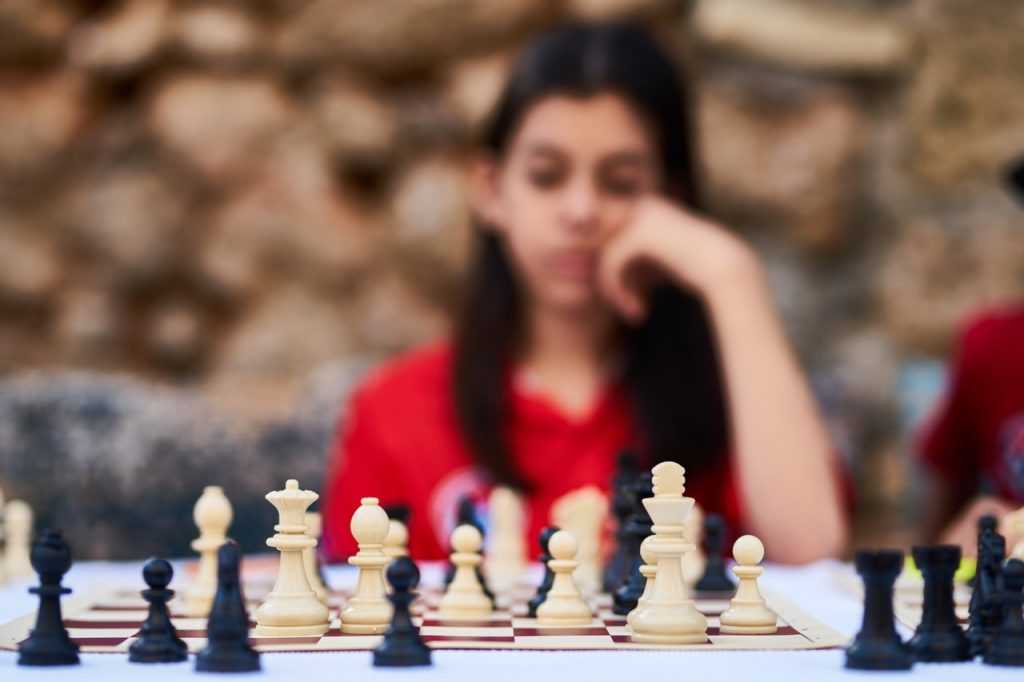 chessboard with blurry person sitting behind the pieces